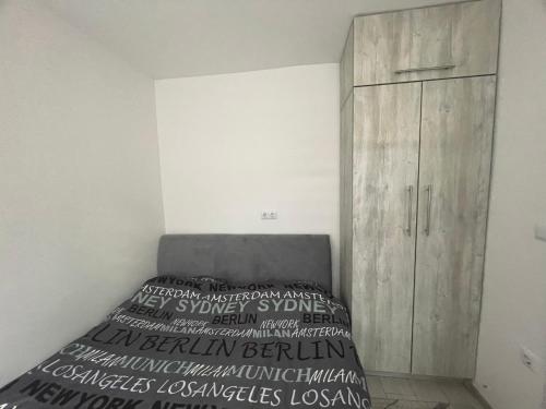 a bedroom with a bed and a wooden cabinet at Mini apartman Smile in Travnik