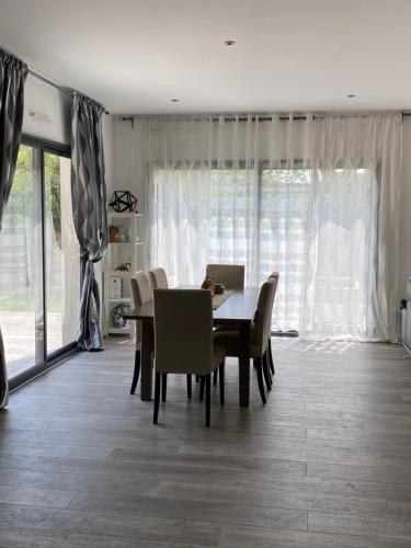 une salle à manger avec une table et des chaises dans l'établissement Villa élégante et chaleureuse proche de Paris, à La Frette-sur-Seine