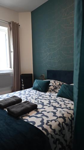 1 dormitorio con 1 cama con pared azul en Superbe Apt T2 en centre-ville, en Marmande