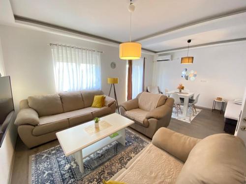 a living room with two couches and a table at Home Mia 2 bedroom apartment in Podgorica