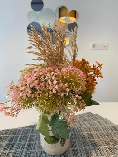 a vase filled with flowers sitting on a table at Home Mia Airport in Podgorica
