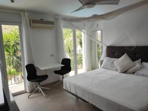 a bedroom with a bed and a desk and chairs at Penthouse Apartment, Cortijo Fruitful HIlls in Málaga