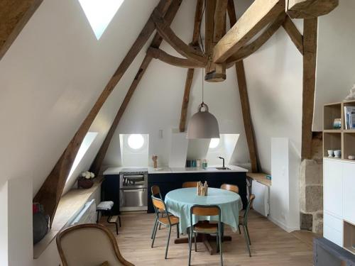 a kitchen with a table and chairs in a attic at Les Embruns in Saint-Vaast-la-Hougue