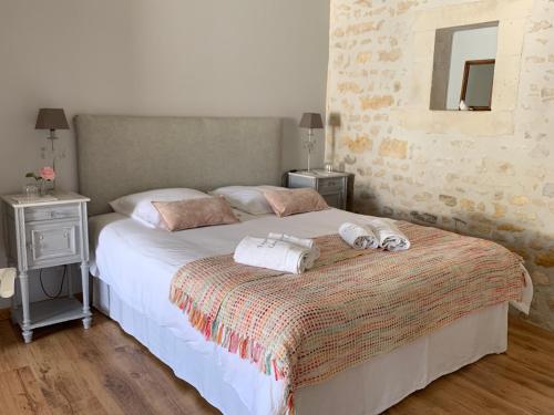 1 dormitorio con 1 cama grande y toallas. en ESPRIT CAMPAGNE, en Montpellier-de-Médillan