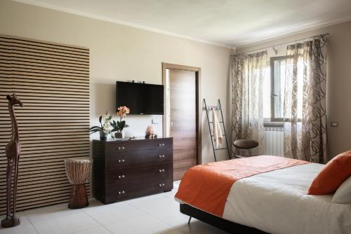 une chambre avec un lit et une commode avec une télévision dans l'établissement A Casa di Elena., à Arezzo