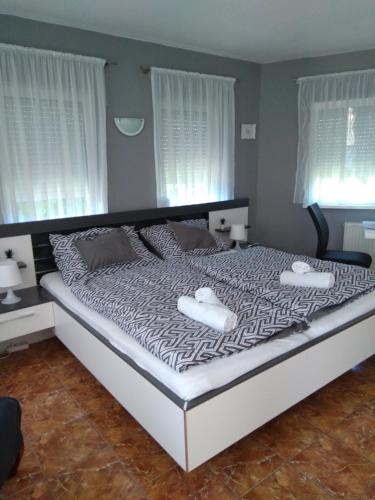 a bedroom with a large bed with two towels on it at Holiday Apartman in Bük