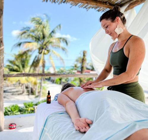 a woman is giving a woman a massage on a bed at Casa Omero Garden in El Cuyo