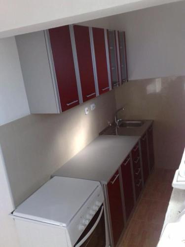 a small kitchen with a sink and a refrigerator at Vila Almas in Ulcinj