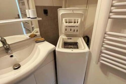 ein weißes Badezimmer mit einem Waschbecken und einem Herd in der Unterkunft L'escale, Studio proche Gare Melun avec parking privé in Dammarie-les-Lys