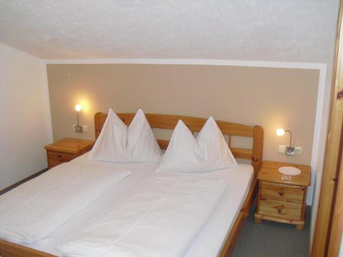 uma grande cama branca com almofadas brancas em Haus Viehhauser em Kleinarl