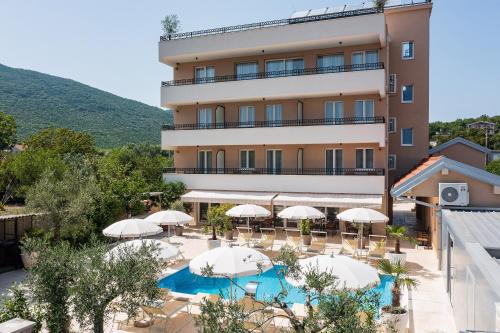 einen externen Blick auf ein Hotel mit Sonnenschirmen und einem Pool in der Unterkunft Villa La Vida in Budva