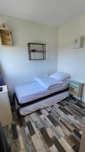 - un lit dans une pièce avec ainyl dans l'établissement Studette à 100m de la plage, à Saint-Jean-de-Monts