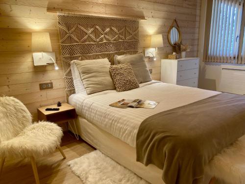 a bedroom with a large bed and a chair at NOTRE CHALET - Boutique Hôtel - En couple - En famille - En groupe in Les Fourgs