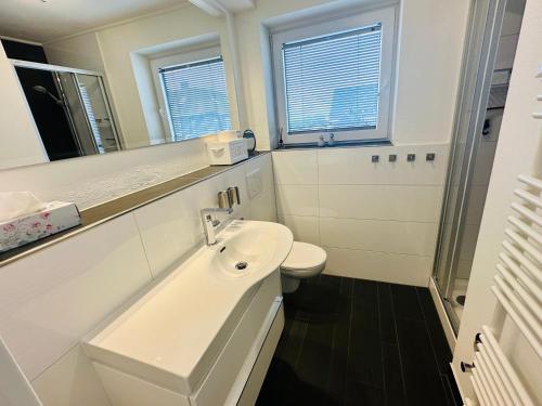 ein weißes Badezimmer mit Waschbecken und Toilette in der Unterkunft Eidum 209 -strandnah- in Westerland