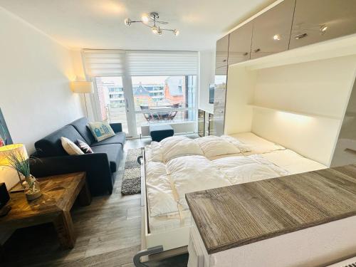 a bedroom with a bed and a living room at Eidum 209 -strandnah- in Westerland (Sylt)