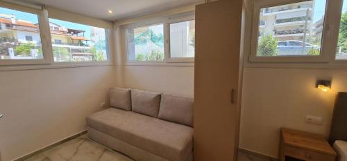 a living room with a couch and two windows at Z Elegant Studios in Perea