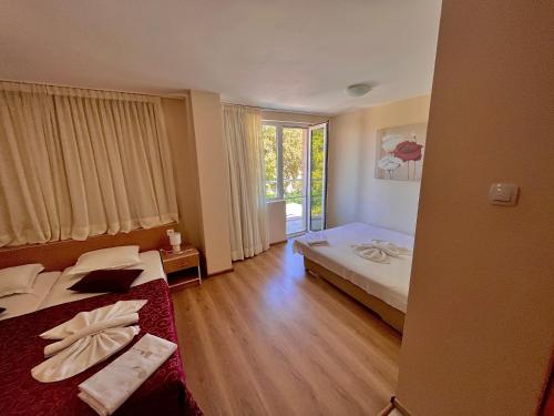 una camera d'albergo con due letti e una finestra di DebiMar a Chernomorets