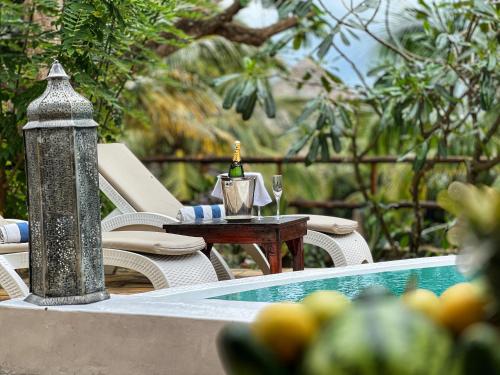 una mesa con una copa de vino junto a una piscina en Natural Kendwa Villa, en Kendwa