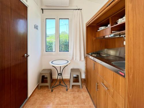 uma pequena cozinha com uma mesa e uma janela em Villa Kostoula Mini house em Karavomylos