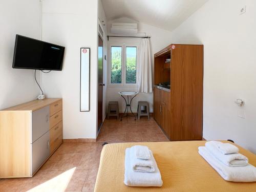 a bedroom with a bed with two towels on it at Villa Kostoula Mini house in Karavomylos