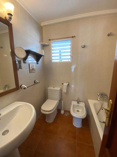 a bathroom with a white toilet and a sink at Piso en la puntilla in El Puerto de Santa María