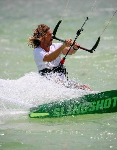 a man riding a board in the water at Casa Omero Seaview. in El Cuyo