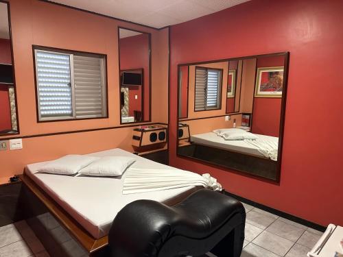 a bedroom with a bed and a mirror at Motel Cigano’s in Belo Horizonte