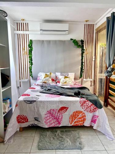 ein Schlafzimmer mit einem Bett mit einer Bettdecke darauf in der Unterkunft La suite parentale in Basse-Terre