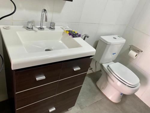 a bathroom with a white sink and a toilet at Hotel Amayal in Puerto Iguazú