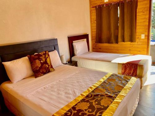 a bedroom with two beds and a window at Hotel Amayal in Puerto Iguazú