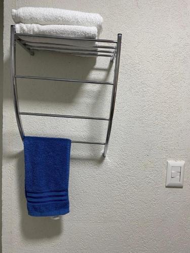 a towel rack with a blue towel on a wall at Hotel Amayal in Puerto Iguazú