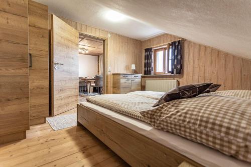 a bedroom with a large bed and wooden walls at Trollenhof im Allgäu - Ferienwohnungen Säuling in Rückholz