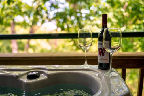 a bottle of wine and two glasses in a sink at Lazy Bear Den in Sevierville
