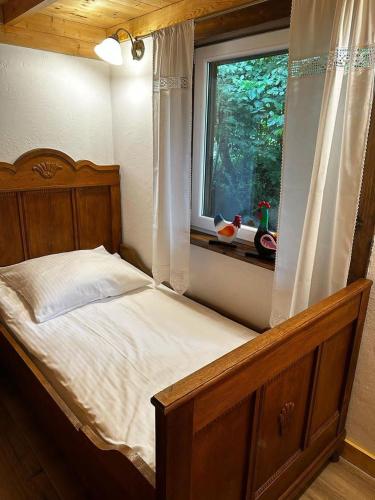 a bedroom with a bed and a window with a chicken on it at Babie Lato in Włodarka