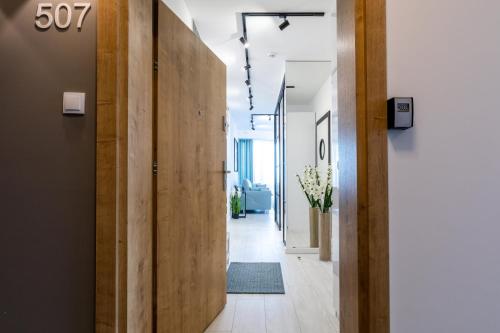 a hallway of an office with wooden walls and a door at Apartament Baltic Porta Mare by Major Domus Club in Dziwnówek