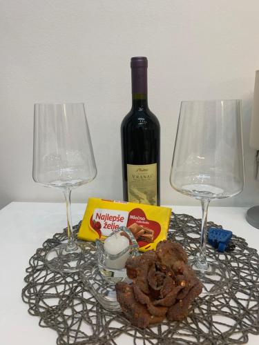 a table with two glasses and a bottle of wine at Guesthouse Vladimir & Ana in Pančevo