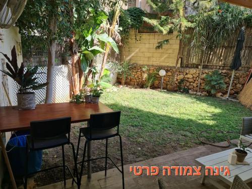 a table and chairs in a backyard with a yard at יחידת דיור (חדר וחצי) - גינה פרטית, חנייה חופשית ! in Herzelia 