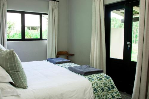 a bedroom with a bed with two blue towels on it at Newstead Farm - Country Cottages in Curryʼs Post