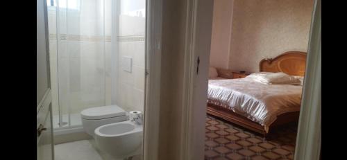 a bathroom with a bed and a toilet and a shower at Albisola bed and breakfast in Albisola Superiore