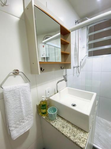 a bathroom with a white sink and a mirror at Charme Copa Retreat próximo ao Copacabana Palace in Rio de Janeiro