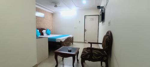 a room with a bed and a table and a chair at Hotel Jigyasa By Mayda Hospitality Pvt. Ltd. in Agra