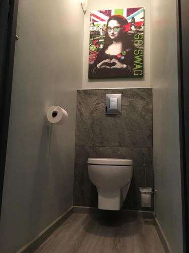 La salle de bains est pourvue de toilettes et d'une affiche murale. dans l'établissement Studio Clos des Meurets, à Praz-sur-Arly