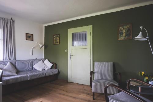 a living room with a gray couch and a door at Chaloupka Na Gruni in Hrádek