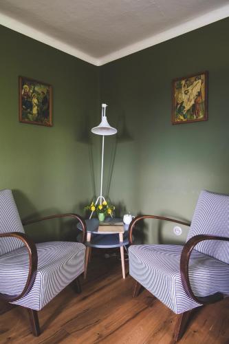 a living room with two chairs and a table at Chaloupka Na Gruni in Hrádek