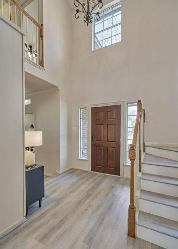 a living room with a staircase and a door at New! Pool, Spa, Nature Trails - The Woodlands 4BR Forest Retreat! in Spring