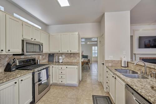 a kitchen with white cabinets and granite counter tops at New! Pool, Spa, Nature Trails - The Woodlands 4BR Forest Retreat! in Spring