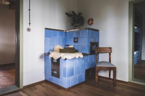a room with a blue tiled wall with a chair at Chaloupka Na Gruni in Hrádek