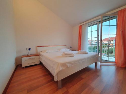 a bedroom with a bed and a large window at Apartments Renato in Zadar