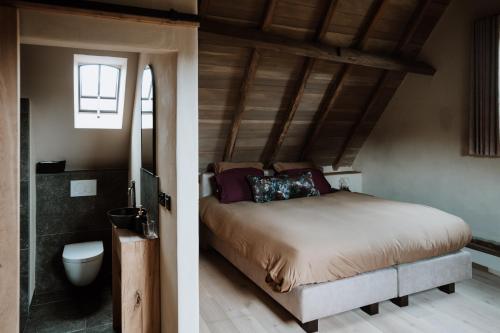 a bedroom with a bed and a bathroom at B@B Martinushoeve in Oudenaarde