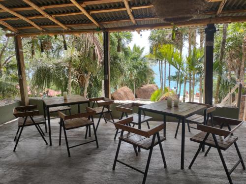 a group of tables and chairs on a patio at Glamping Asana Bacalar in Bacalar